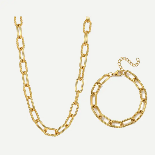 Gold paperclip chain necklace and matching bracelet set on a light gray background.