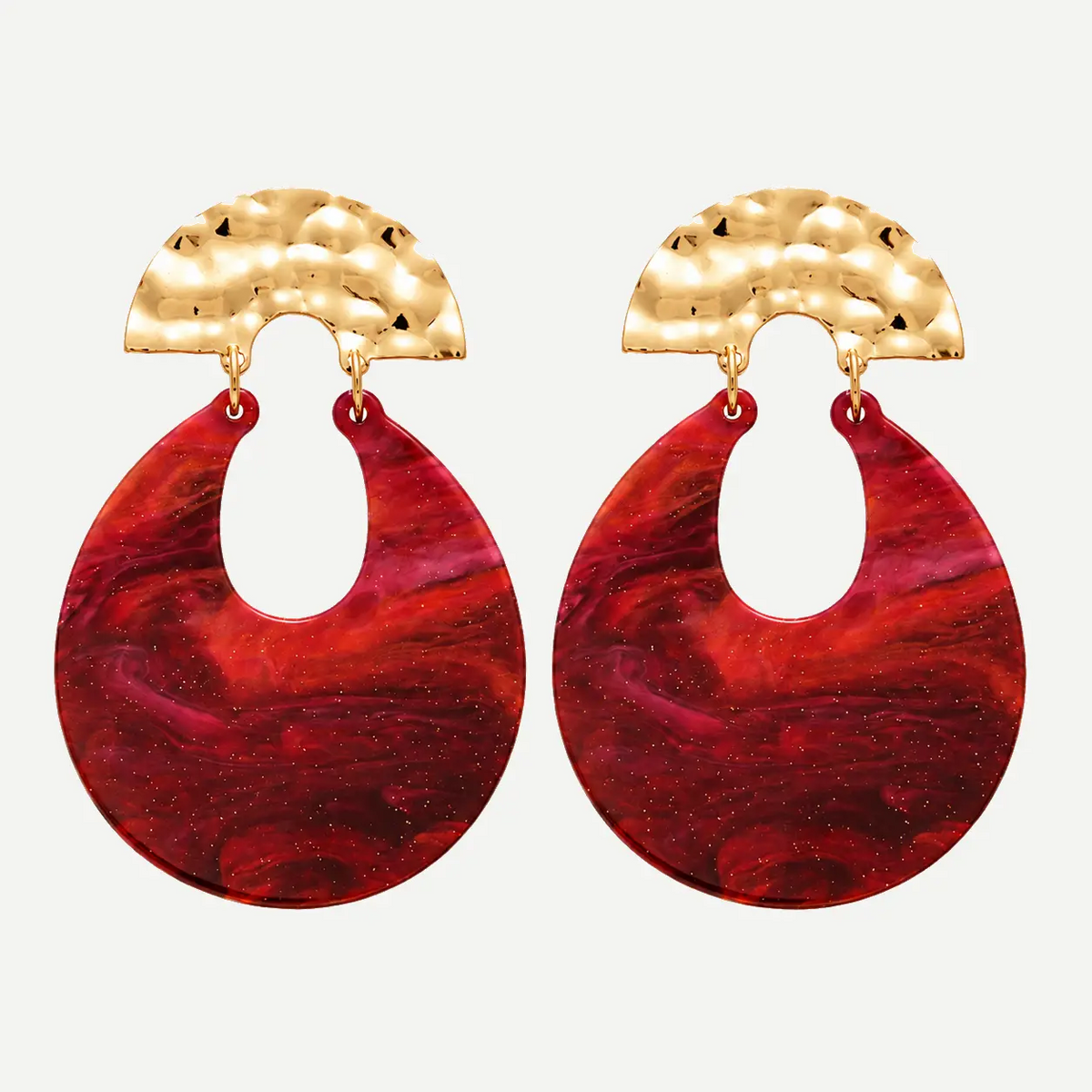 A pair of statement dangle earrings featuring textured hammered gold semi-circular tops and large teardrop-shaped red and magenta marbled resin drops, shown against a light gray background.