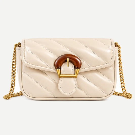 A cream-colored quilted patent leather shoulder bag with a brown faux-bamboo clasp and a gold-tone chain strap, shown against a light gray background.