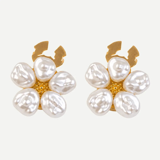 A pair of gold and pearl flower-shaped earrings on a light gray background.